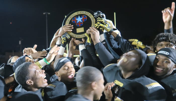 Neumann-Goretti players raise the Catholic League plaque.
